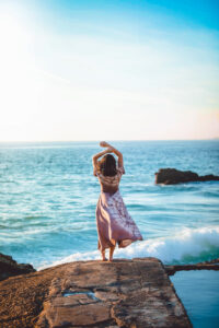 Woman enjoying the ocean view at sunset near SKHAI luxury real estate.