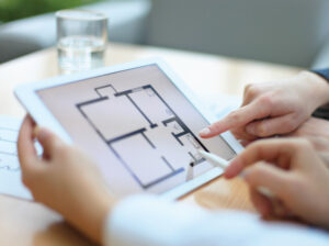 Clients reviewing a floor plan on a tablet for SKHAI luxury real estate.