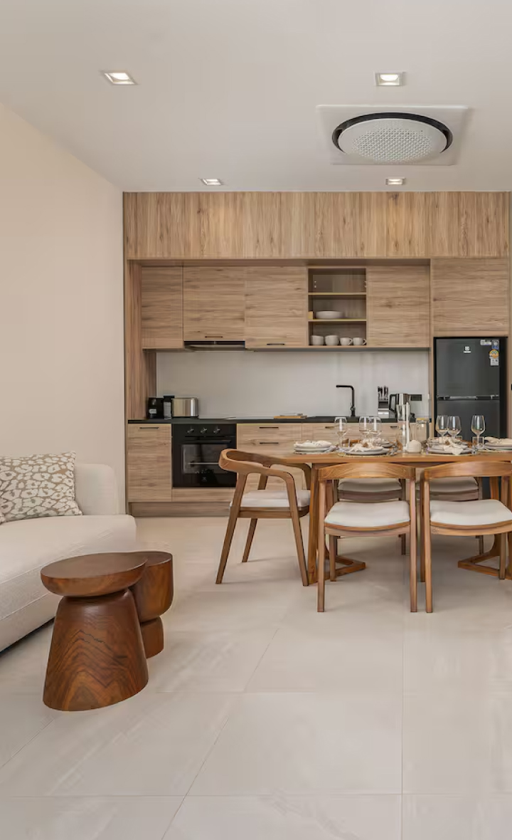 Modern kitchen and dining area in tropical pool villas Bangtao Phuket, showcasing wood accents and sleek design.