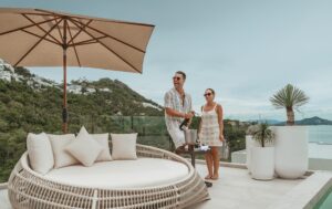 Couple enjoying champagne on SKHAI villa terrace with stunning views